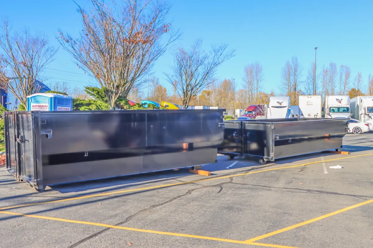 Professional dumpster rental service with roll-off container on residential driveway in Flushing